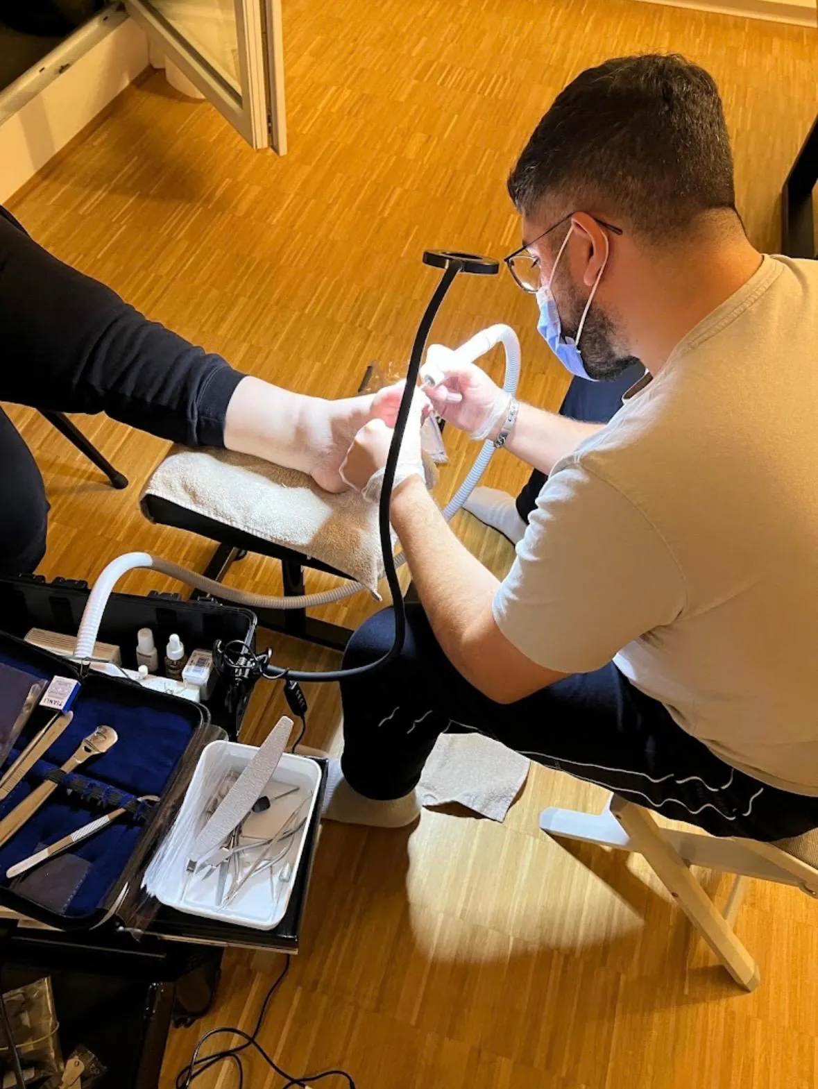 Sevket Öven behandelt einen Kunden zu Hause — mit Mundschutz, Handschuhen und mobilem Instrumentenkoffer